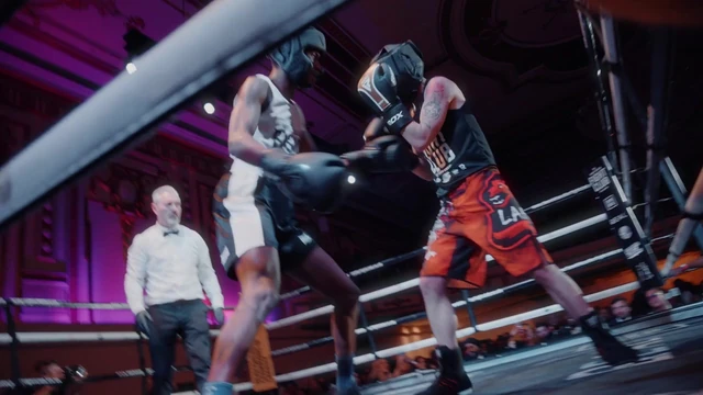 Two fighters trading punches as the referee watches at a black tie fight night