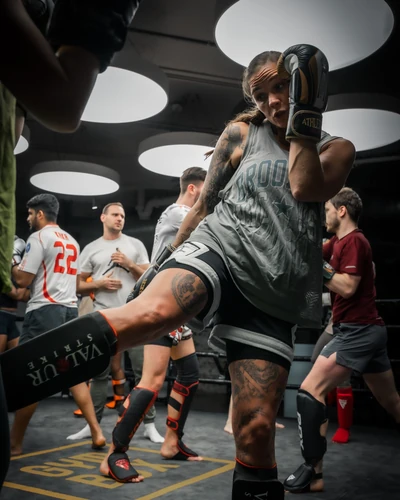 A woman throwing a kick in a Muay Thai class