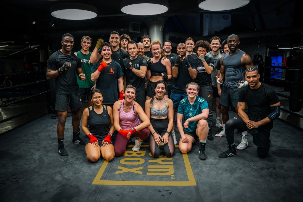 A fight camp group in gloves and training kit, lined up together at Gymbox