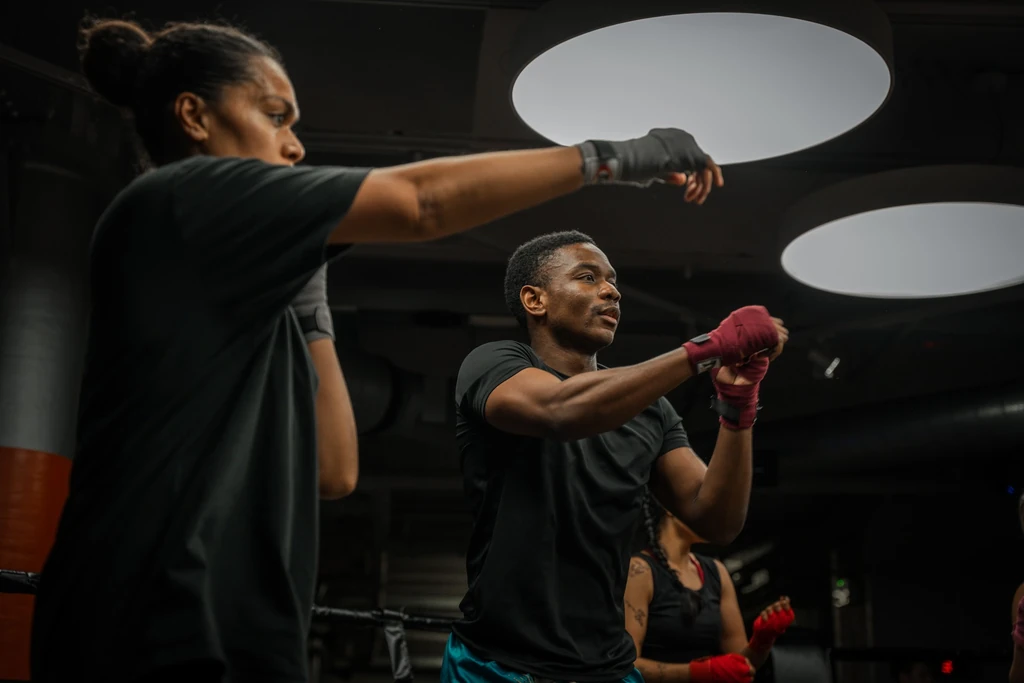 Two fighters in hand wraps shadow boxing at fight camp